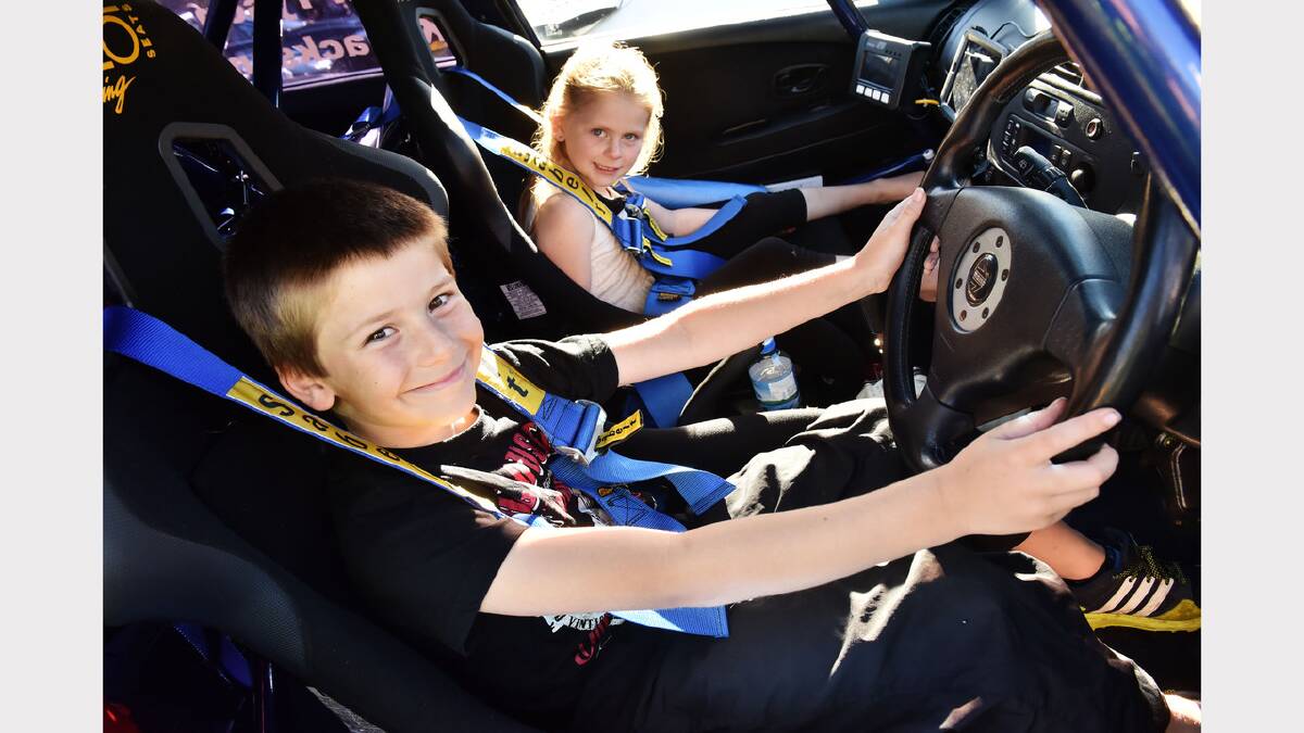 Zane, 8, and Shakiah Roney, 7, of George Town get comfortable in a 1999 Mitsubishi Lancer Evo VI. Picture: Scott Gelston