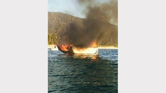 A wooden boat off the state's East Coast became engulfed in flames on Tuesday night after an electrical problem. Picture: Tasmania Police, Facebook