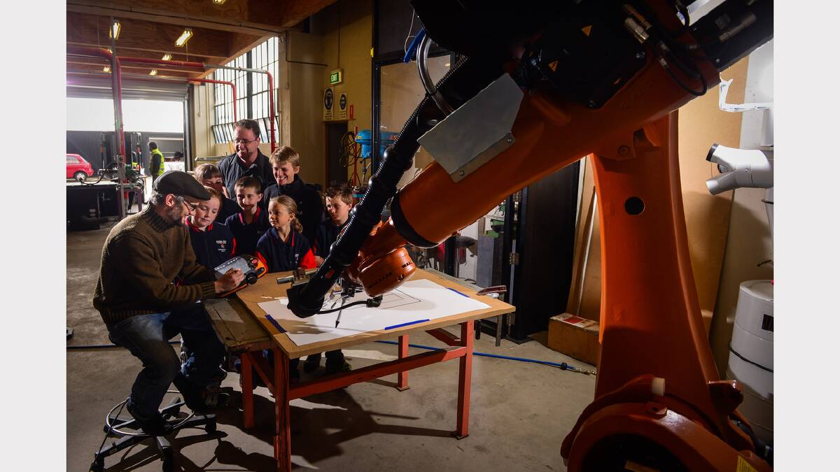 School of Architecture and Design Digital Technologies lecturer Peter Booth demonstrates a six-axis industrial KUKA robot to Gagebrook Primary School students Lakiesha Pearce, Maree Wakefield, Andrew Arnol, Sophie Knysak, Callum Smedley, along with third-year UTAS Environmental Design student Paul Casburn and 24 Carrot project manager Bridgette Watts. Picture: Phillip Biggs