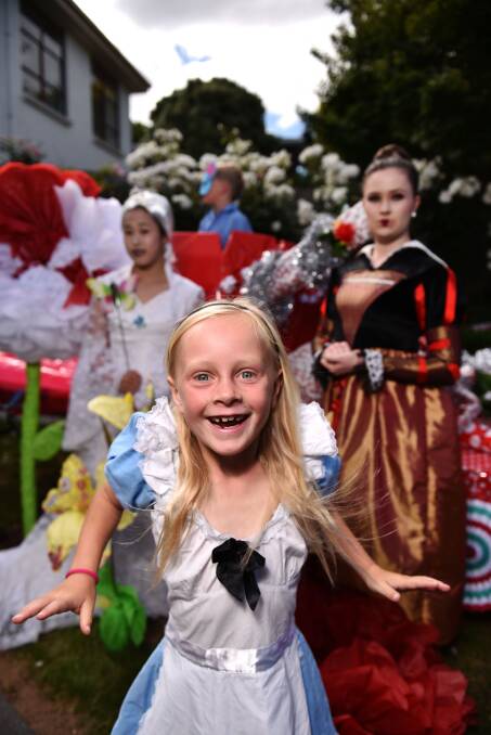 Mackenzie Chiselett , 8, as Alice in Wonderland, gets ready to ride on a float in Saturday's Christmas parade.