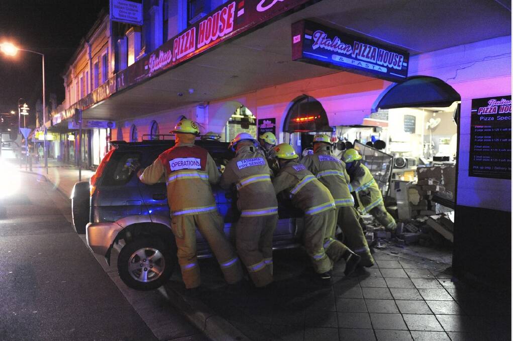 Fire crews remove a small SUV from the Italian Pizza House on Thursday night. Picture: MARK JESSER