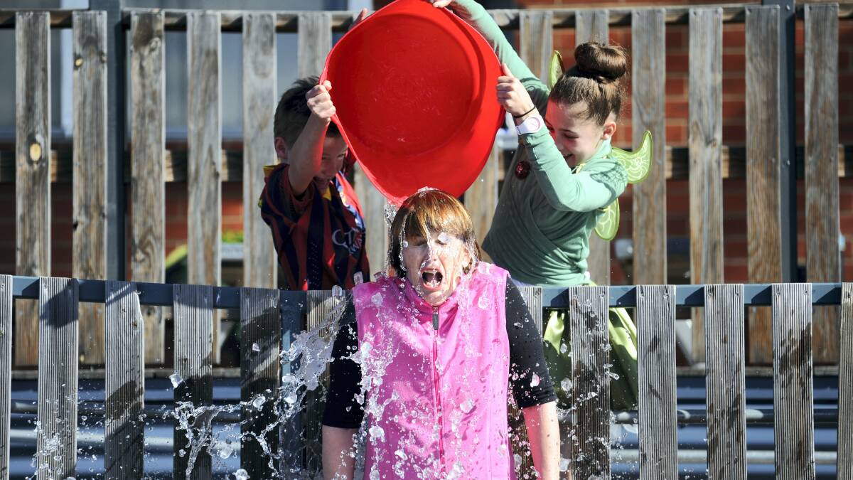 Punchbowl Primary School pupils   Henry, 9, and Molly Woolcock, 12, and  teacher Loretta Kenny  in the ice  bucket challenge yesterday.  Picture: MARK JESSER