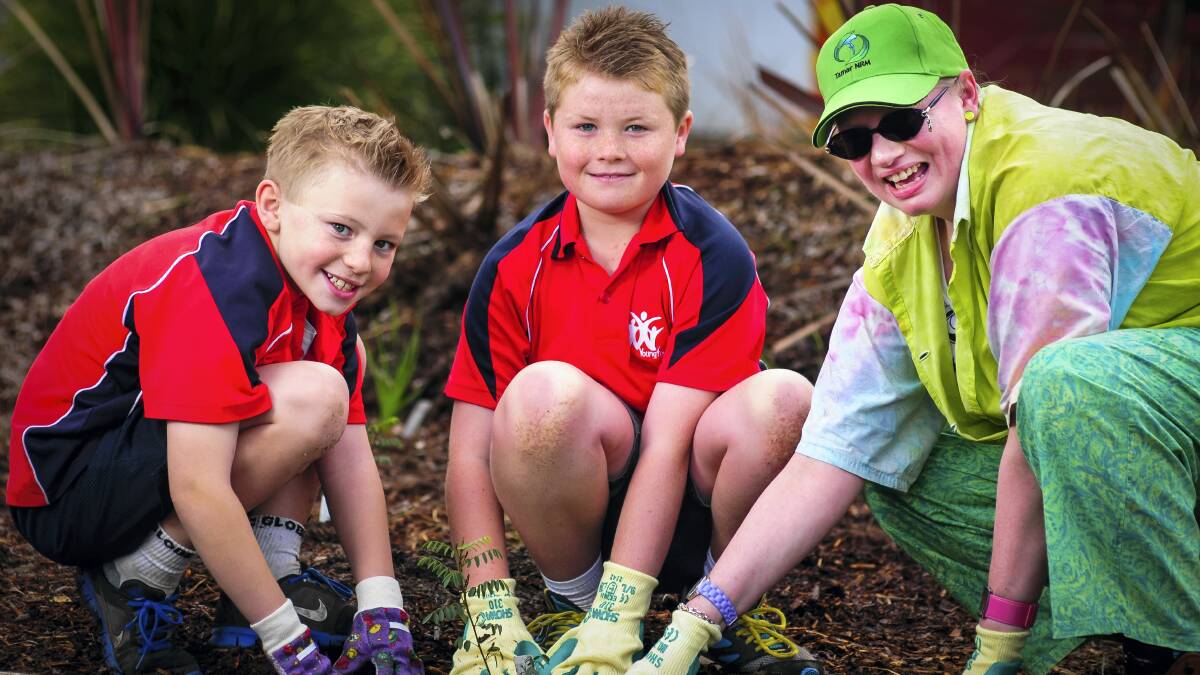 Getting their hands dirty at  yesterday's Schools Tree Day are Youngtown Primary School's Haydon Eaby and Caleb Chapple, and Tamar Natural Resource Management  officer manager Amanda Bruce.  Picture: PHILLIP BIGGS