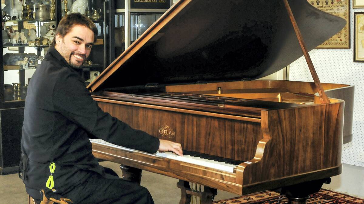 Armitage Auctions employee David Jordaan playing a piano that is up for auction tomorrow. Picture: NEIL RICHARDSON
