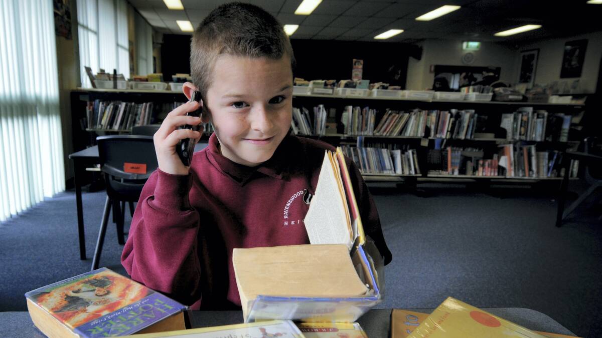 Ty Forrest, 10, on the phone to his reading buddy as part of The Smith Family Literacy program at Ravenswood Heights Primary School. Picture: GEOFF ROBSON