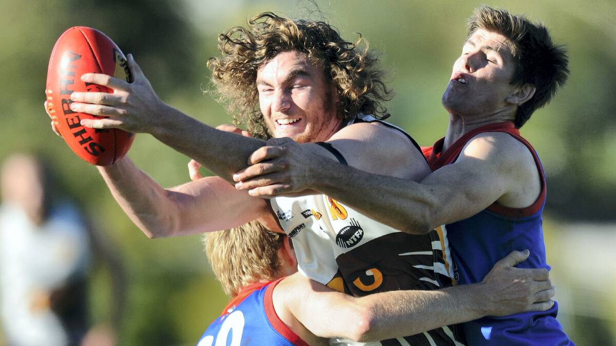Prospect Hawks player Andrew Zammit is crunched in a tackle from Lilydale pair Billy Tuckerman and Jesse Tuckerman in their NTFA division 2 clash yesterday. Pictures: MARK JESSER.