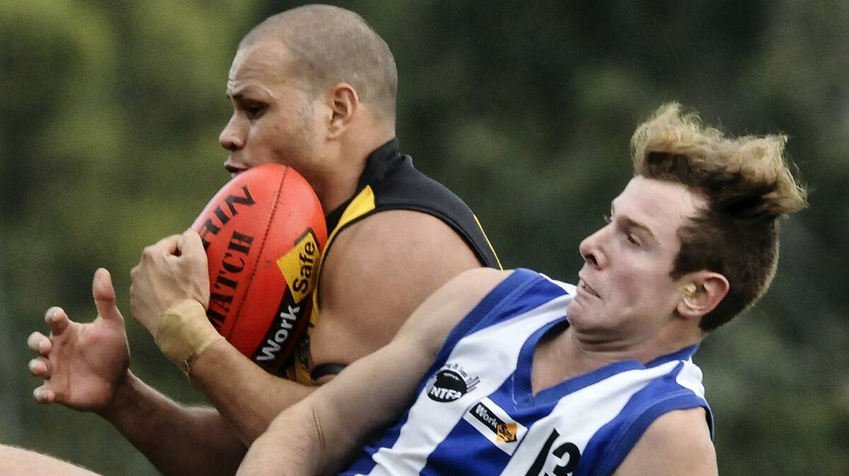 Former AFL player Daniel Motlop, playing for  Rocherlea,  takes a  mark under pressure from Deloraine's Marcus Lee in yesterday's NTFA clash. Picture: NEIL RICHARDSON