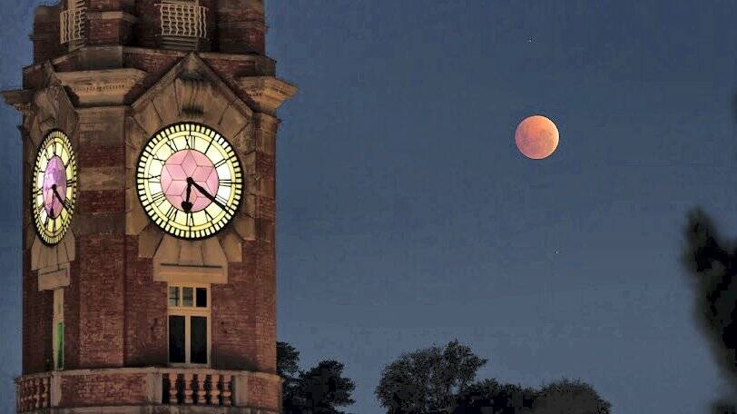 The reddish glow of the moon seen beside the Launceston Post Office clock last night. Picture: RICHARD COWLING