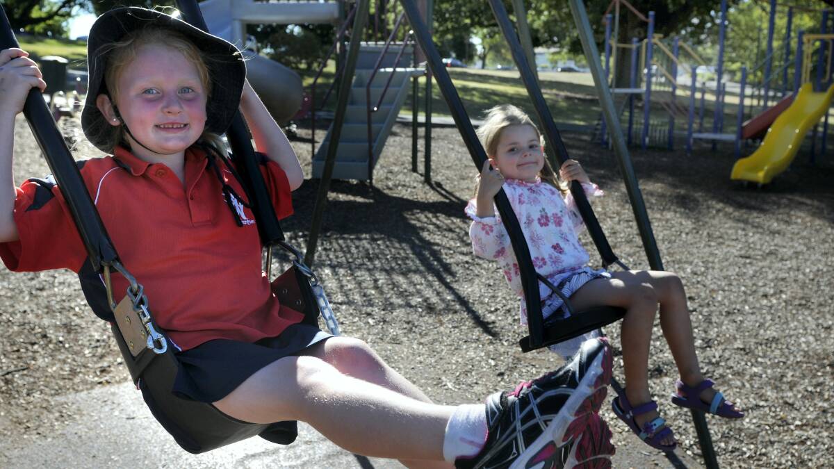 Brianna Watts, 5, of Youngtown, and Erin Bishop, 5, of South Launceston, on the swings in the playground at St Georges Square. Picture: PAUL SCAMBLER