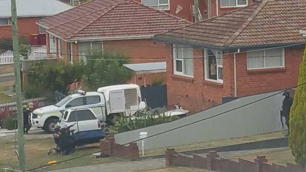 A supplied photo of the Cedar Street home, with the alleged offender in the window of the property, with members of the special operations group watching on. 