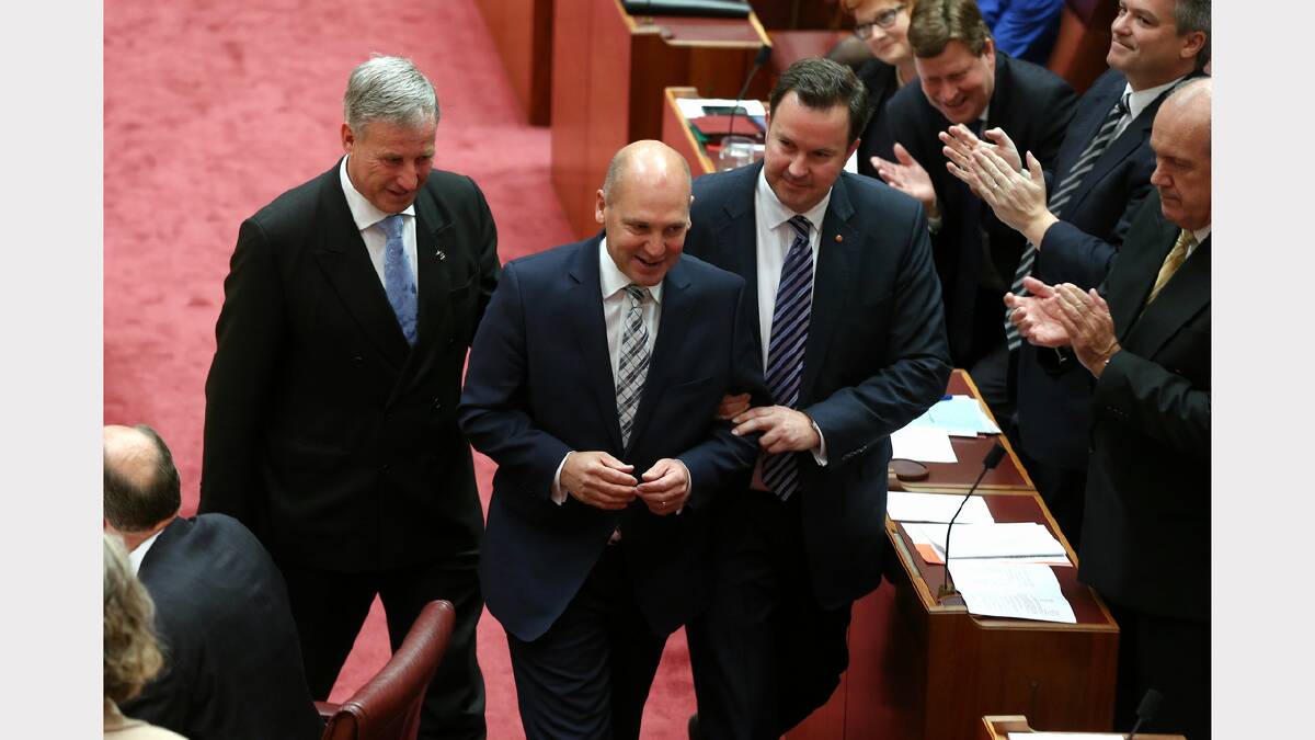 Senator Richard Colbeck (left) and Senator David Bushby (right) "drag" the new President of the Senate, Senator Stephen Parry to the chair, at Parliament House in Canberra on Monday. Photo: Alex Ellinghausen