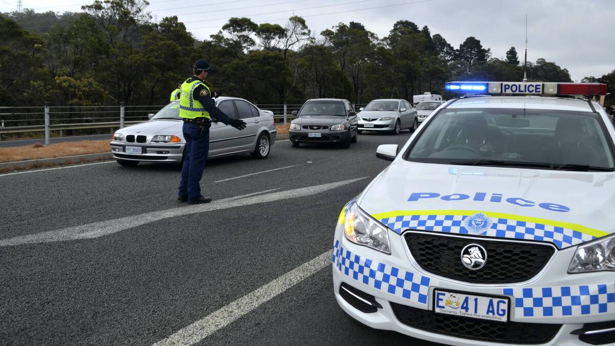 Police search cars at a road block on the East Derwent Highway. Picture: GEORGIE BURGESS