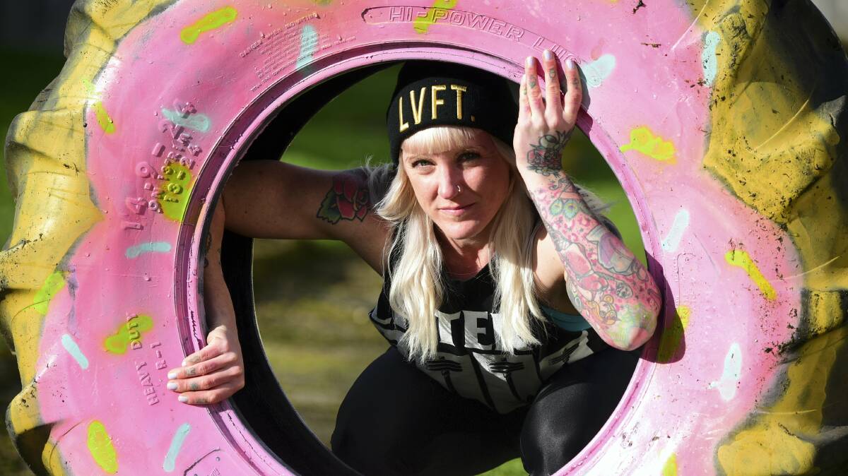 Launceston’s Lucy McCarroll with her backyard training tool, a truck tyre. Miss McCarroll came first in the Strongman Tasmania round one, women under 63.5kg category. Picture: PAUL SCAMBLER