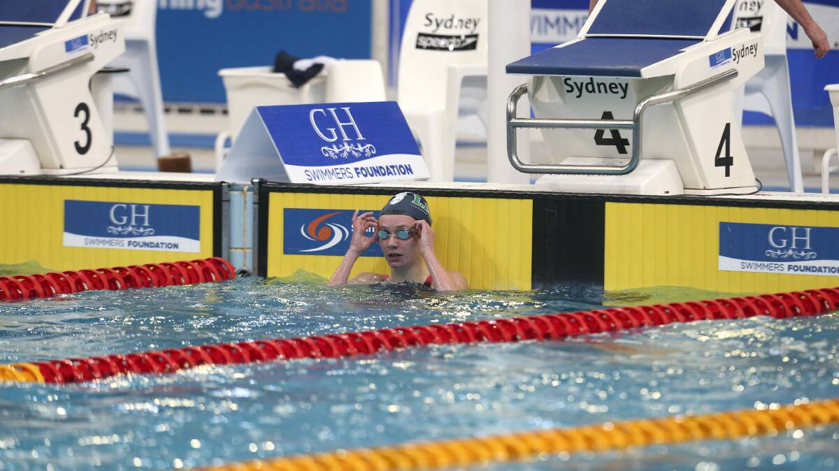 Launceston teenager Ariarne Titmus glances up to the scoreboard after securing gold in the 200m freestyle at the national age championships in Sydney on Monday night. 