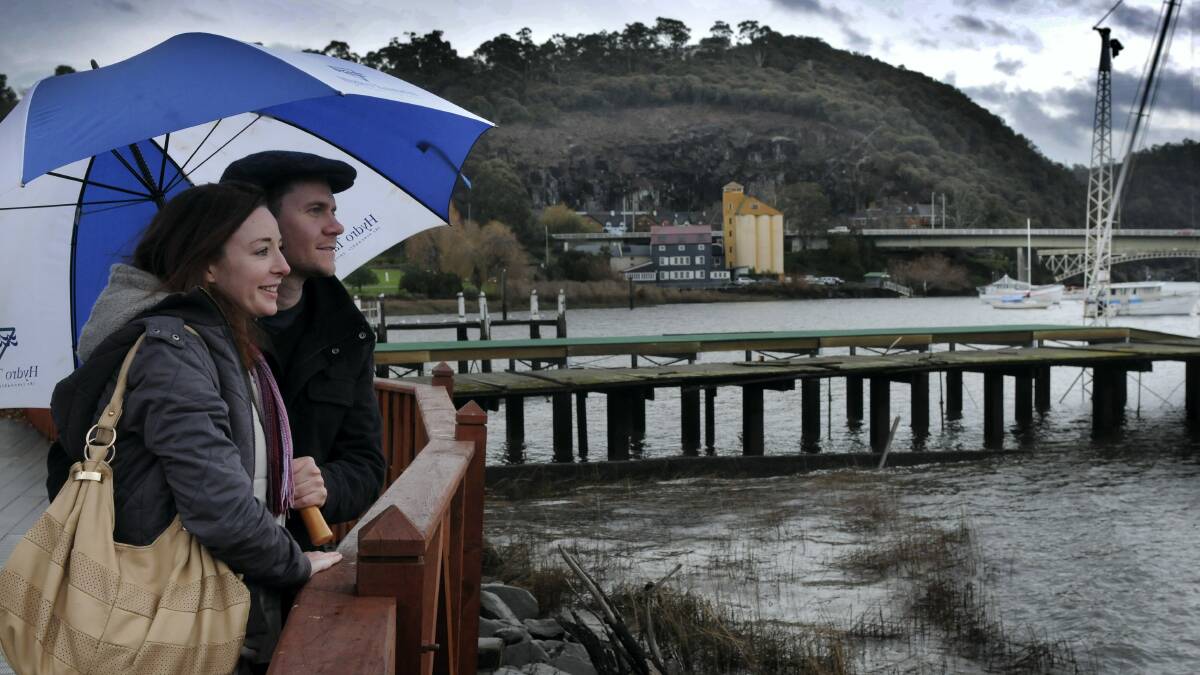 Brisbane tourists Nadine Lester and Rob Ibbs shelter under an umbrella as they take in the view at Royal Park yesterday. Picture:  PAUL SCAMBLER