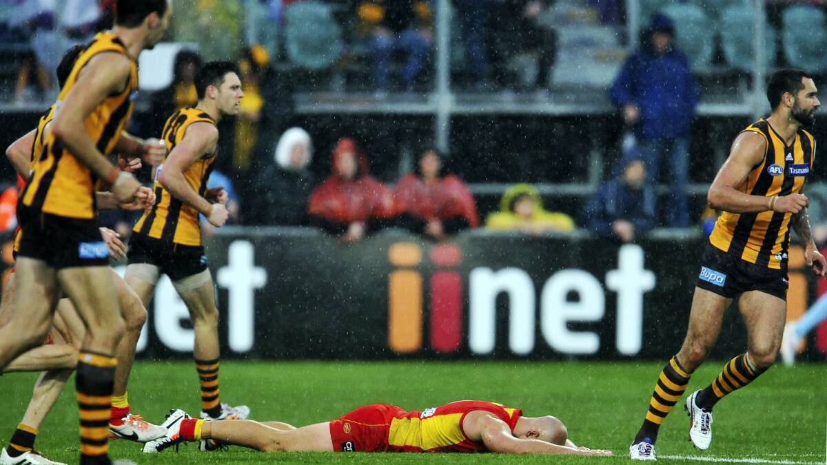 Gary Ablett lies face-down as his Suns are overrun by the Hawks at Aurora Stadium yesterday. Picture: SCOTT GELSTON
