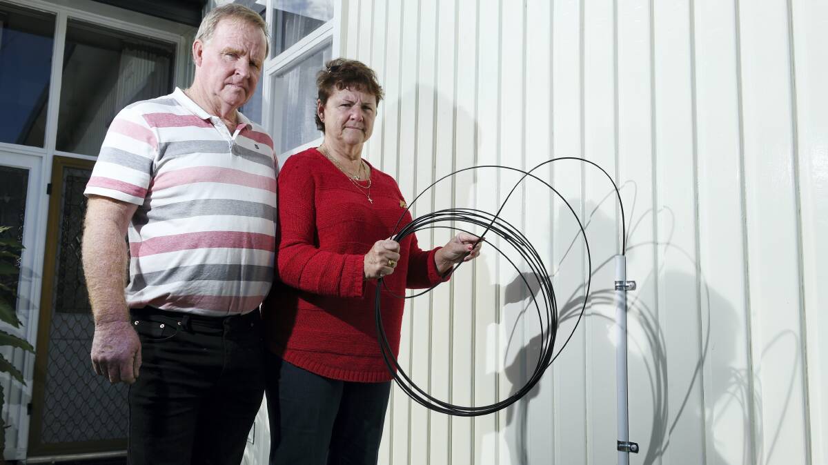 Rodney and Terry Youd, of Trevallyn,  with the NBN cable that was installed under their home without their permission.  The cable is now coming through the wall at the front of the house.  Picture: MARK JESSER