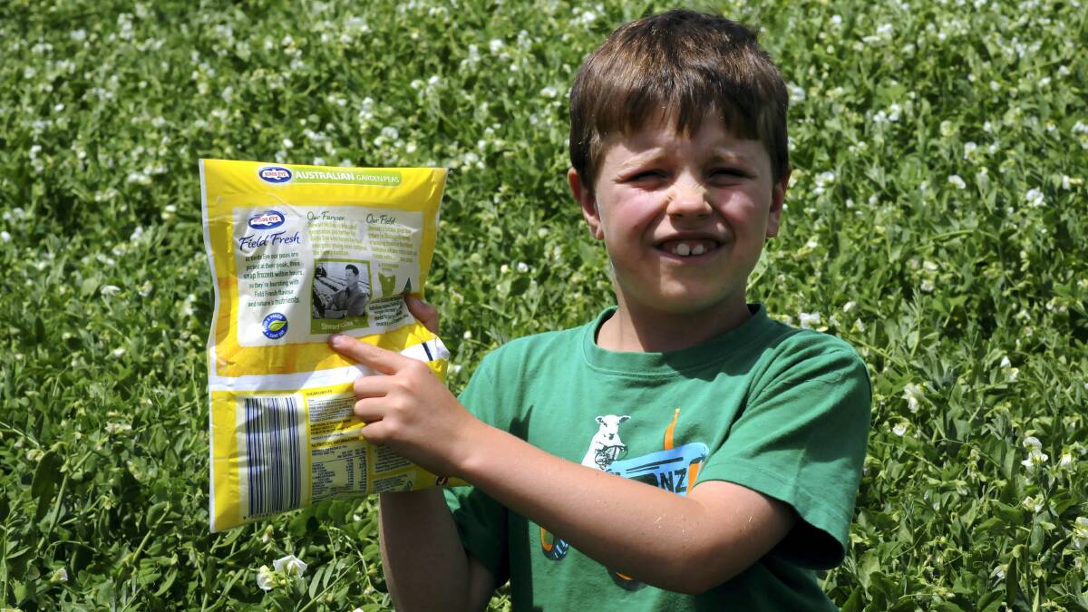 Jack McGee, 7, of Bishopsbourne, holds a pack of peas with his father Stewart’s photo on them. Picture: NEIL RICHARDSON