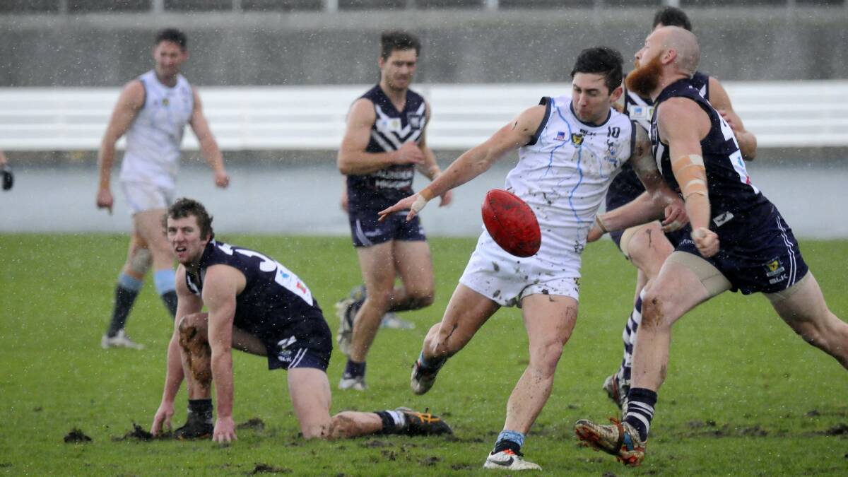 Burnie's Nick McKenna (right) tries to close in on Western Storm's Thane Bardenhagen as fellow Docker Brodie Knight looks on. Picture: PAUL SCAMBLER