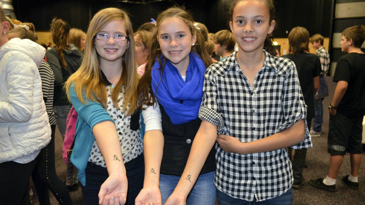 Ebony Black, of Riverside, Kristen Riley, of Legana, and Sofia Bailey, of Riverside, all 13, flaunting their friendship tattoos.