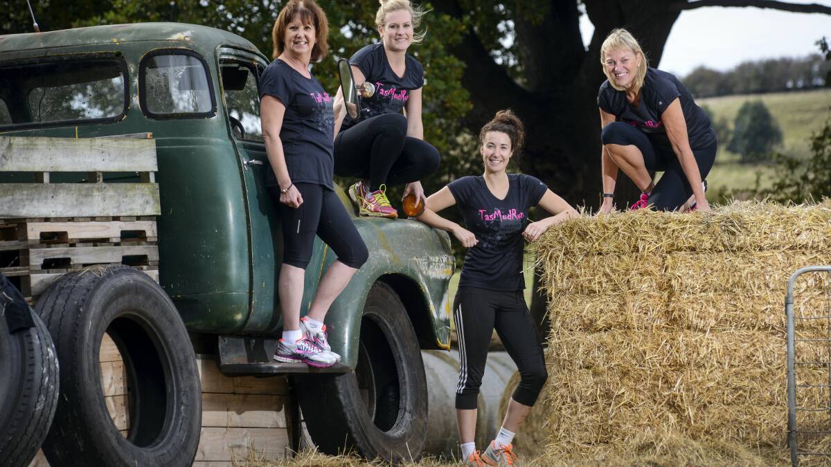 Runners Lisa Coulson, Chloe Moore, Georgia Axton and  Caroline Guest with an old Bedford truck at the start line of this weekend's Tas Mud Run. Picture: PHILLIP BIGGS

