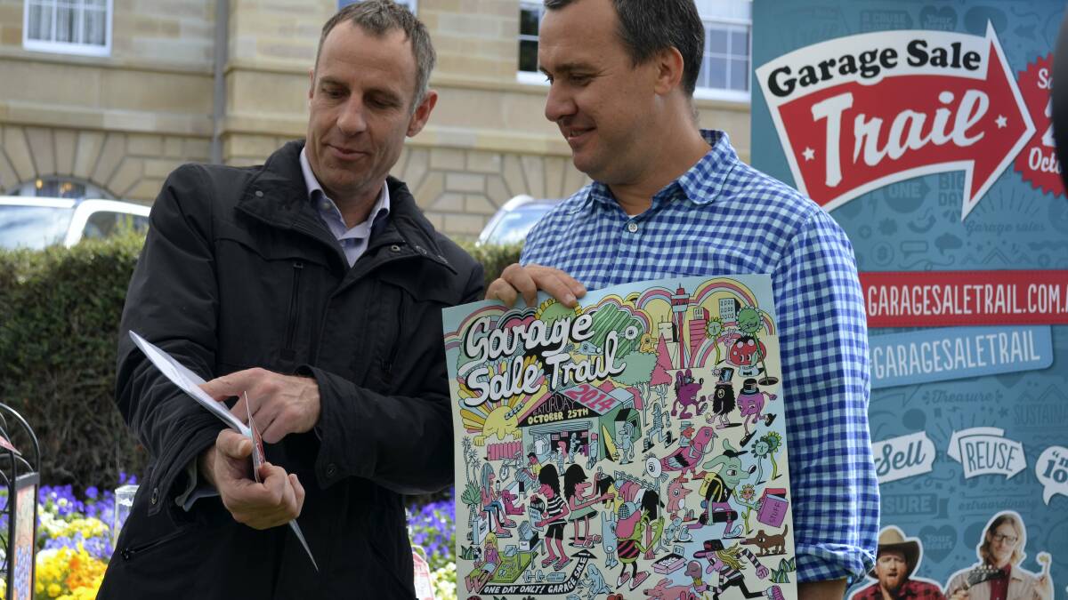 Franklin Greens MHA Nick McKim with Garage Sale Trail co-founder Darryl Nichols  at yesterday’s Parliament House fund-raising sale. RIGHT: An original Rainbow Warrior poster donated by Denison Greens MHA  Cassy O’Connor for yesterday’s sale.