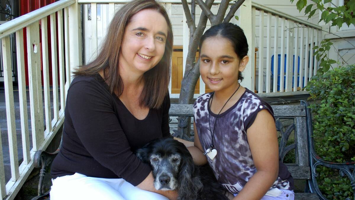 Bass Labor MHA Michelle O'Byrne at home in Launceston with one of her two daughters, Sophia Arumugam, 11. They are holding the family dog, Maddy.