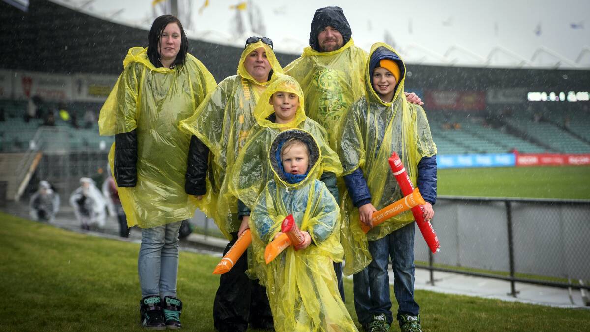 At the AFL Hawthorn versus Gold Coast game at Aurora Stadium are, back, Richelle Smith, 14, mum Heidi Smith, dad Damien Smith with Mason Smith, 1  (wrapped up with dad), and, front, Geneva Smith, 3, Morgan Smith, 9, and Bailey Smith, 12, all of Hobart. Picture: MARK JESSER