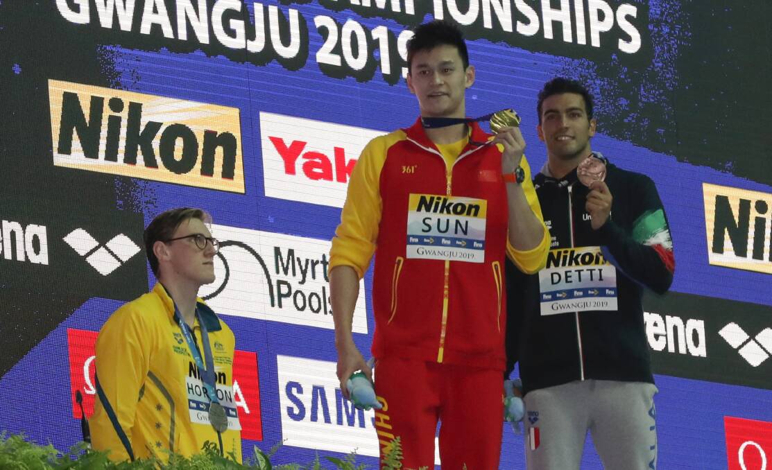 Making a stand: Australia's silver medallist Mack Horton stands away from the podium as China's Sun Yang shows his gold medal after the men's 400m freestyle final at the World Swimming Championships in South Korea. Picture: AP