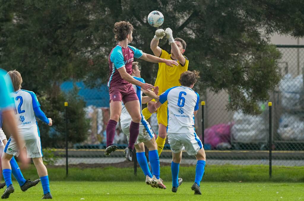 FLYING HIGH: Lachlan Dean challenges Olympia keeper Mitchell Stalker.