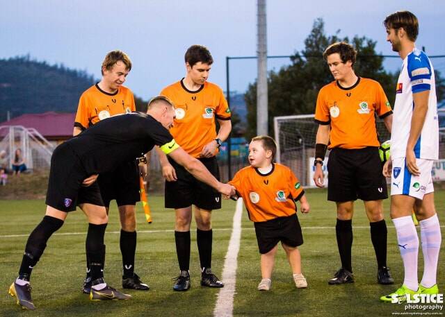 Official sanction: Tony Peart and his team of referees welcome a mascot before an NPL Tasmania match. Picture: Solstice Digital