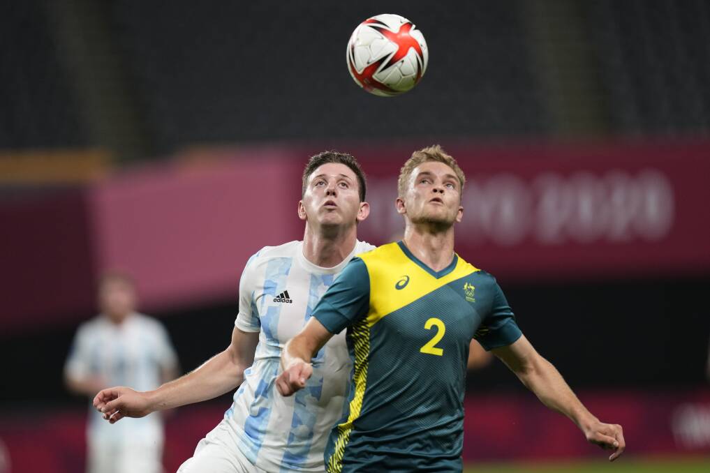 Heads up: Australia's Nathaniel Atknison challenges Argentina's Adolfo Gaich during their Olympic soccer match in Sapporo, Japan. Picture: SIlvia Izquierdo, AP