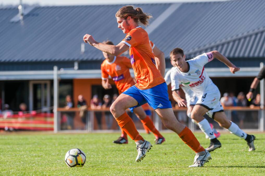 Orange zest: Riverside Olympic defender 
Rohan Fenner in action against Hobart 
Zebras in the Lakoseljac Cup earlier 
this season with the new clubhouse in 
the background. Picture: Phillip Biggs