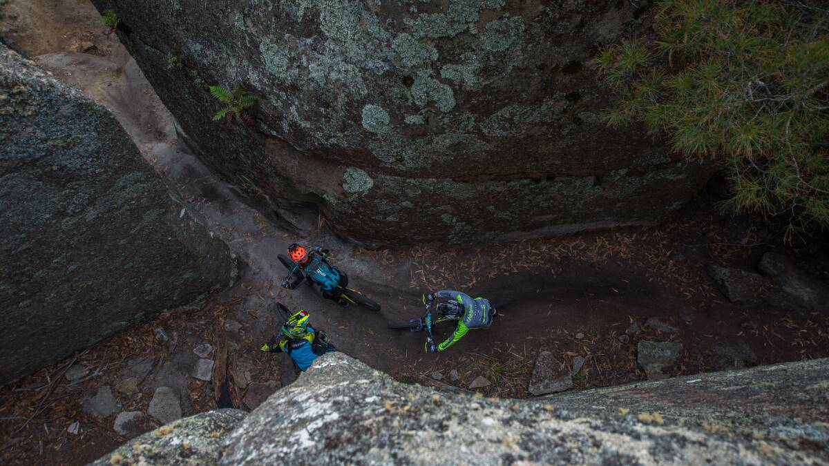 Rock and a hard place: Riders tackle the notorious chute between giant boulders on the Derby mountain bike network. Picture: Scott Gelston