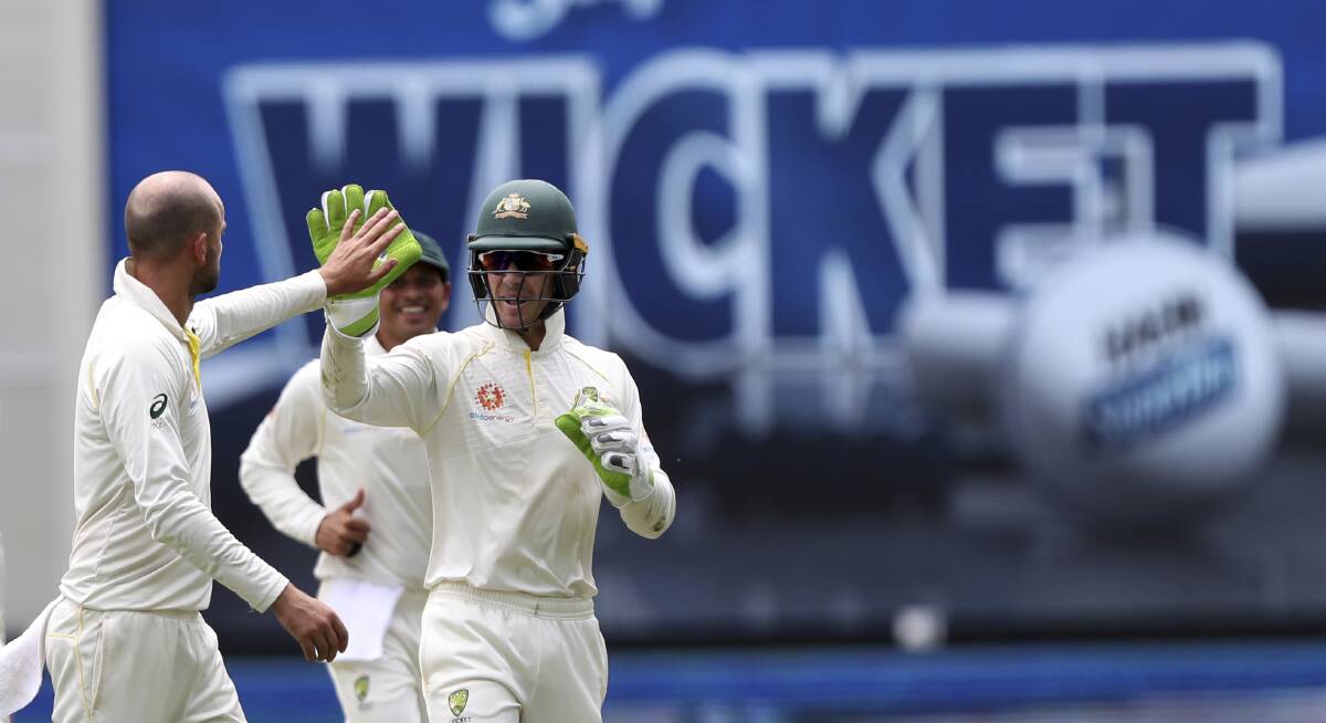 Over and out: Nathan Lyon and Tim Paine celebrate the televising of an Indian wicket.