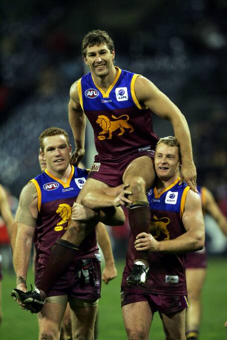 LYNCHPIN: Champion Brisbane forward Alastair Lynch is chaired off by Justin Leppitsch and Michael Voss after his 300th game. Picture: Fairfax 