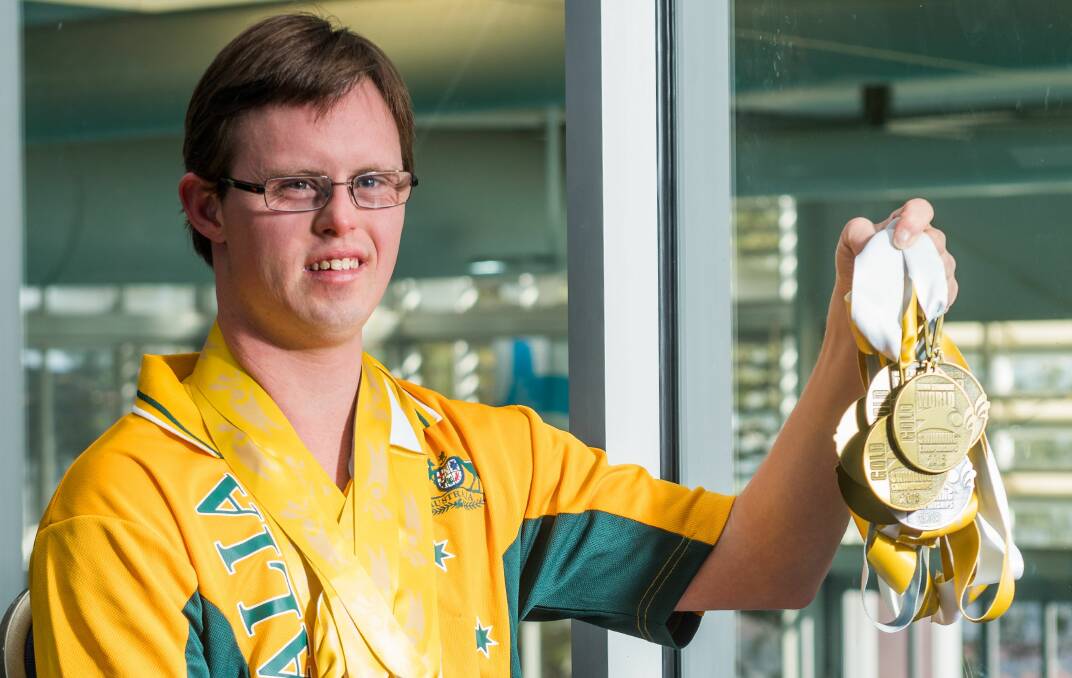 Gold finger: Aran Miller with his medal haul at Launceston Aquatic Centre. Picture: Phillip Biggs