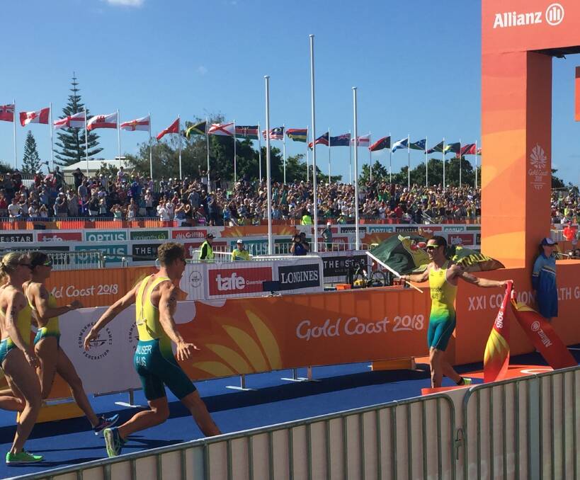 Flag bearer: Jake Birtwhistle leads Australia to triathlon mixed team relay gold at the Commonwealth Games in April. Picture: Rob Shaw