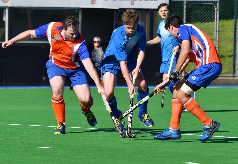 SANDWICH: Burnie's Keenan Johnson weaves his way through the Devonport defence during the Greater Northern League hockey men's match. Picture: Brodie Weeding. 