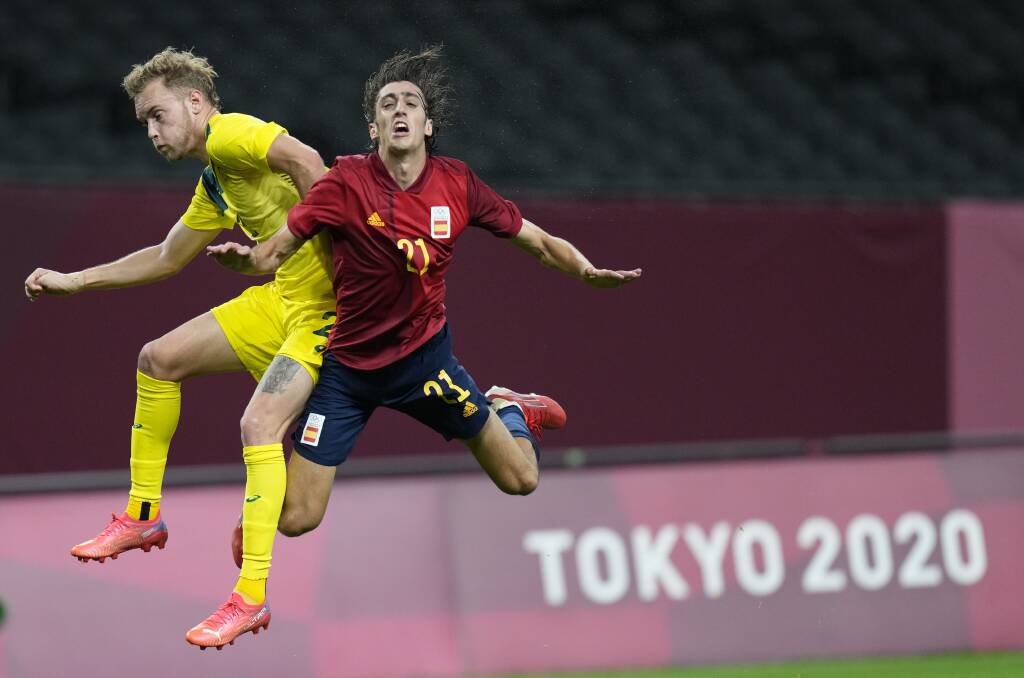 Nathaniel Atkinson hits the heights as the Olyroos take on Spain. Picture: AP