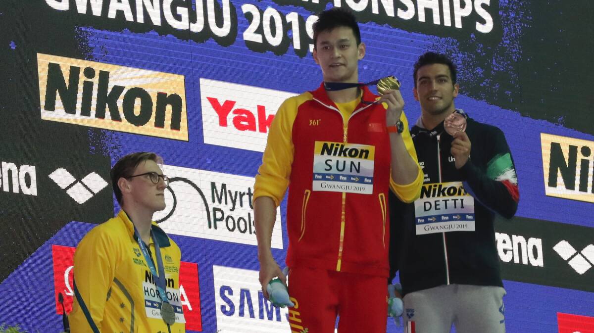 Taken aback: Australia's Mack Horton takes a step back as China's Sun Yang shows his gold medal after the men's 400m freestyle final at the World Swimming Championships in South Korea. Picture: AP