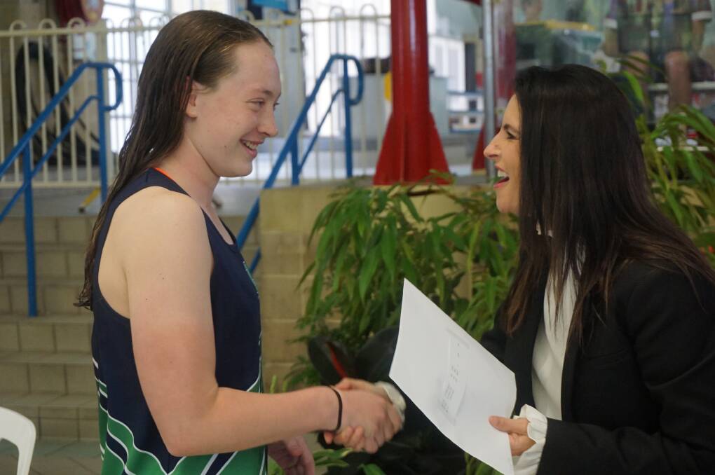 Emily Mitchell, of LAC, receives an award from Sports Minister Jane Howlett at the state championships.