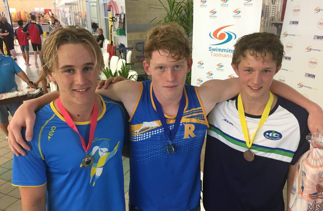 Jordan Cooper and Tom Sladden, of Riverside, and Max Powell, of HC Swim Club, after the boys' 14-15 100m butterfly.