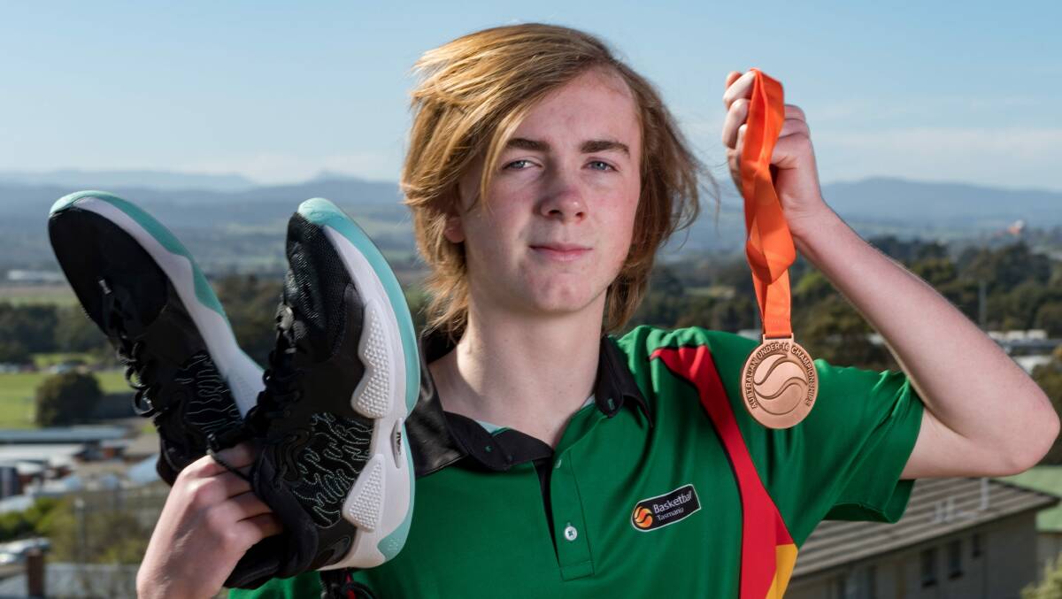 Inspiring message: Lachie May proudly displays his shoes and medal from the Australian under-16 basketball champs. Picture: Phillip Biggs
