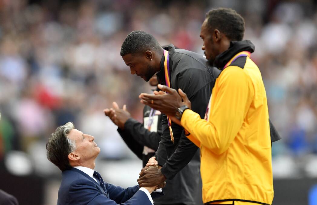 Well done: Gold medallist Justin Gatlin is congratulated by Sebastian Coe as bronze medalist Usain Bolt watches during the medal ceremony for the men's 100 meters at the world athletics championships in London. Picture: AP