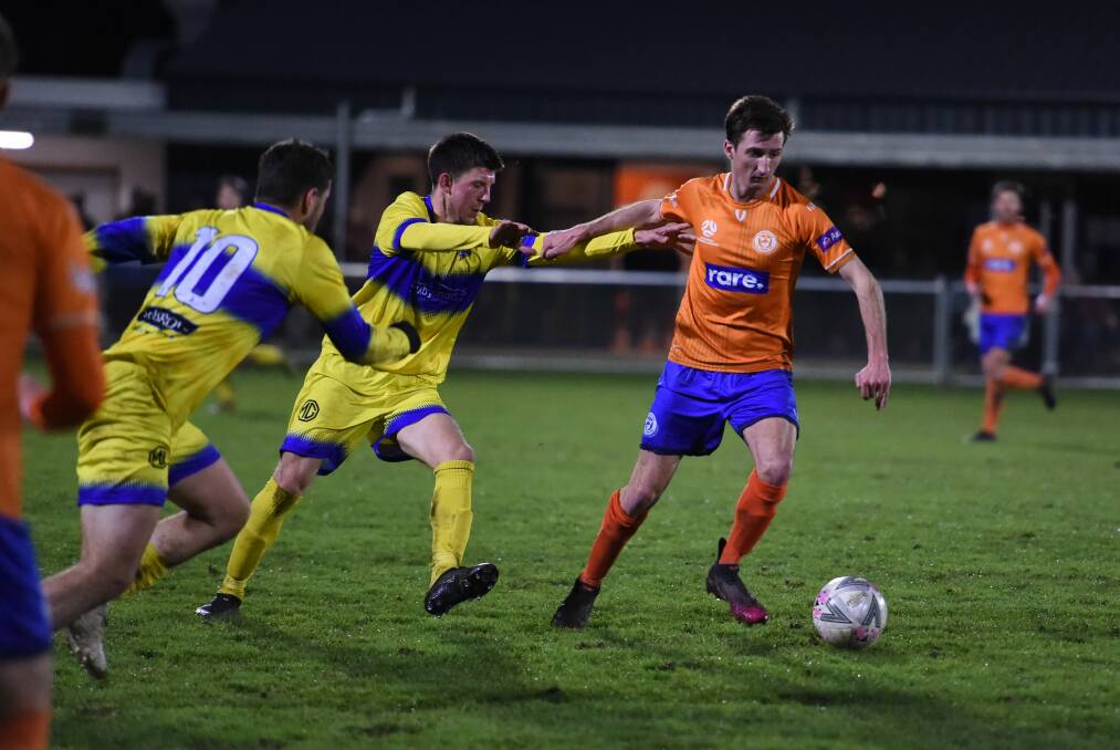 Under siege: Olympic's Mitch Jones against Devonport in Tuesday's match at Windsor Park. Picture: Floyd Jones