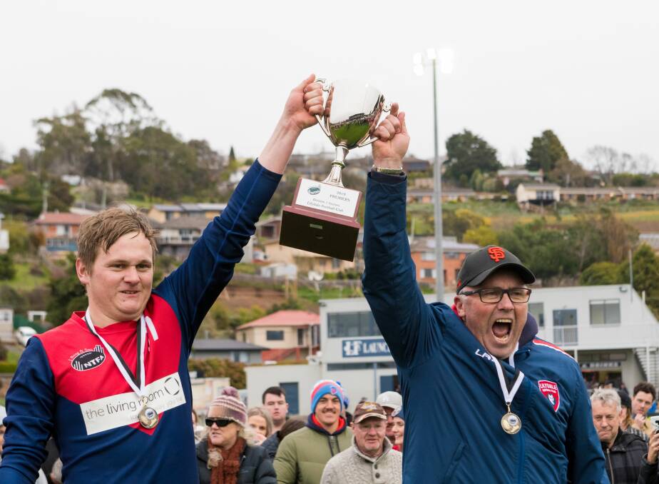 Premiers: Lilydale captain Corey Lockett and coach Colin Lockhart stand with the premiership cup aloft. Picture: Phillip Biggs
