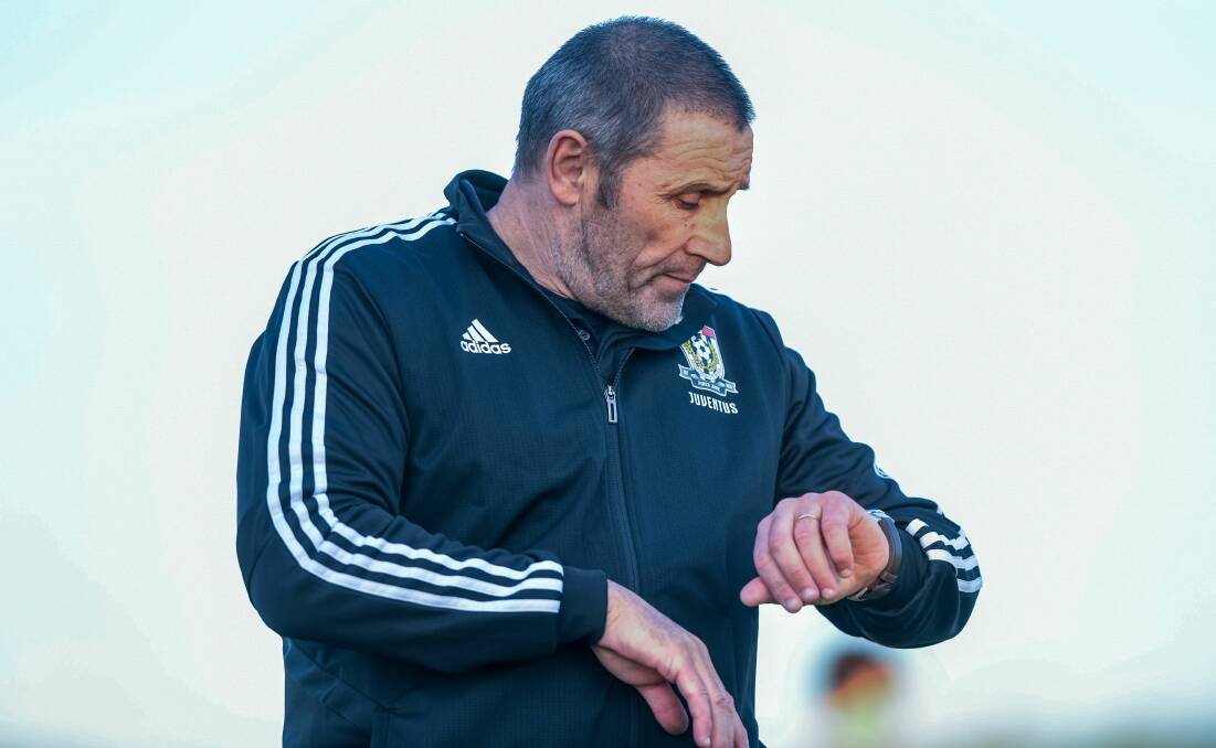 Time to go: Lino Sciulli checks his watch while coaching Launceston City. Picture: Neil Richardson