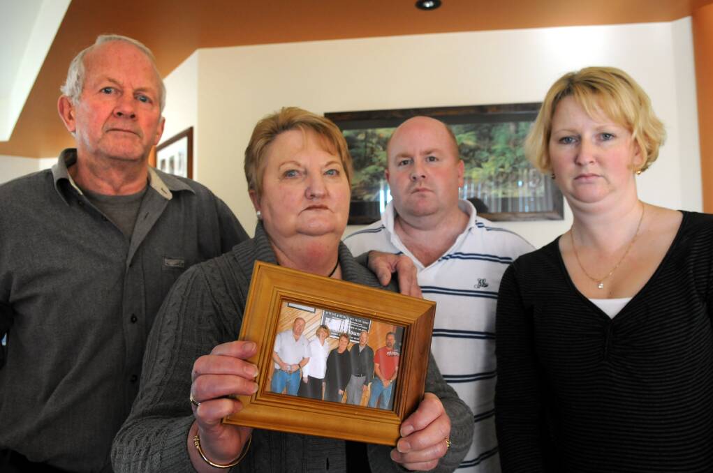 Robert and Barbara Barker, with son Paul Barker and daughter Nicole Garwood, holding the last family photo including Shane. 