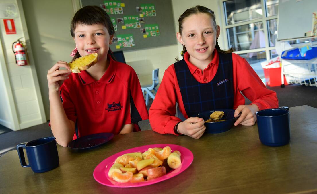 FRESH: Grade 3 students, Blaise Fitzallen, 9, and Makayla Holmes, 9, enjoying their fruit and toast prepared by volunteers of the Breakfast Program. Picture: Paul Scambler